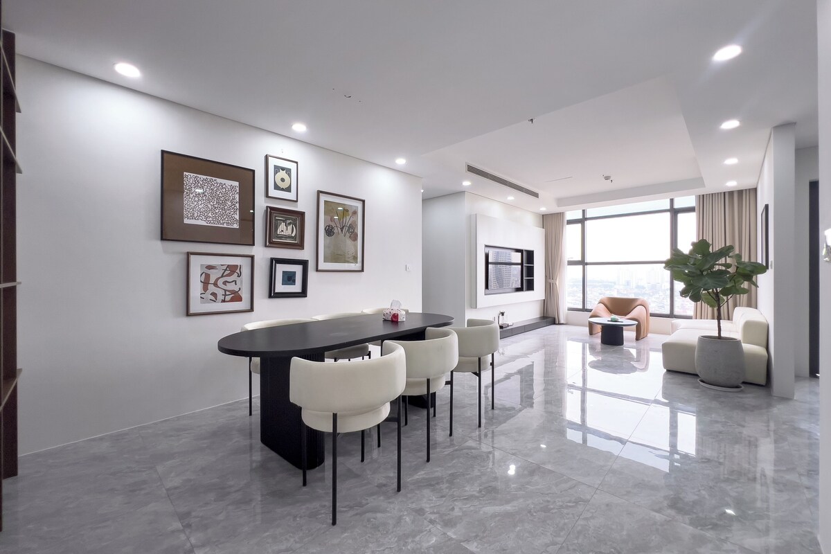 A modern interior with a dining area, a large window, and artwork on the walls.
