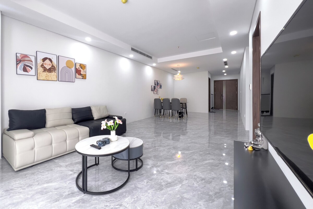 A modern living room with a sofa, coffee table, and dining area.