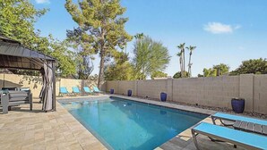A swimming pool with lounge chairs and a covered seating area. - Resort backyard and pool - close to everything (Mesa)