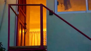 Een trap die leidt naar een kamer met een raam, een deur en een hanglamp.