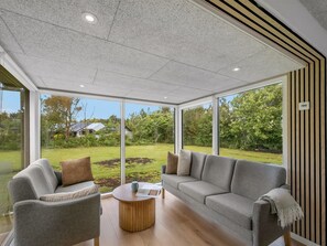 A modern living room with a grey sofa, armchairs, and a wooden coffee table. - "Jonnhild" - 100m to the fjord by Interhome (Tarm)