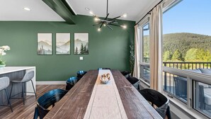 Een eethoek met een lange houten tafel, meerdere stoelen en een decoratief middelpunt.