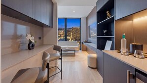 Eine moderne Küche mit Blick auf die Stadt, ein Essbereich mit einer Couch und Stühlen sowie eine kleine Bar mit Regalen.