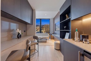Eine moderne Küche mit Blick auf die Stadt, ein Essbereich mit einer Couch und Stühlen sowie eine kleine Bar mit Regalen.
