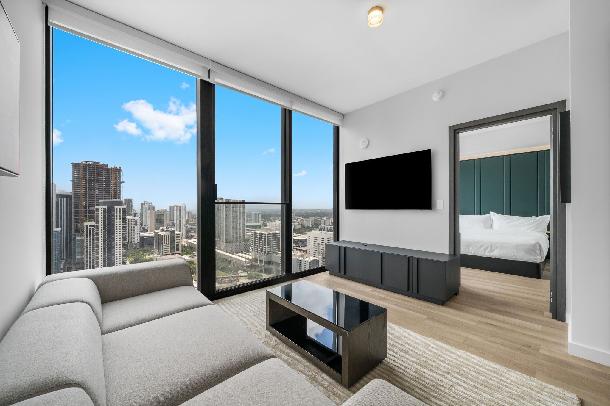 A modern living room with a sofa, a coffee table, and a TV mounted on the wall.