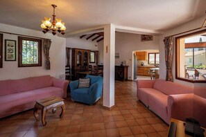 A living room with two sofas, a coffee table, and a chandelier. - Villa Sleeps 12 with Outdoor Pool (Laroque-Des-Albères)