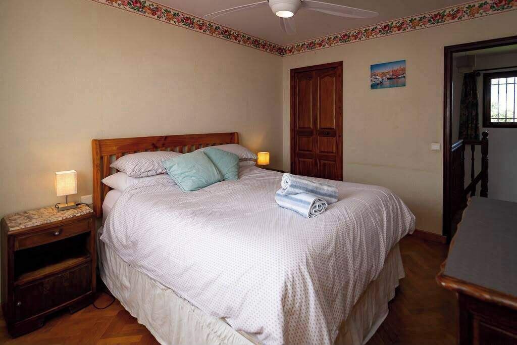A bedroom with a bed, nightstand, and a door.