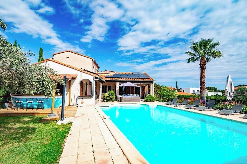 Ein Wohnhaus mit Swimmingpool, überdachter Terrasse und Meerblick.