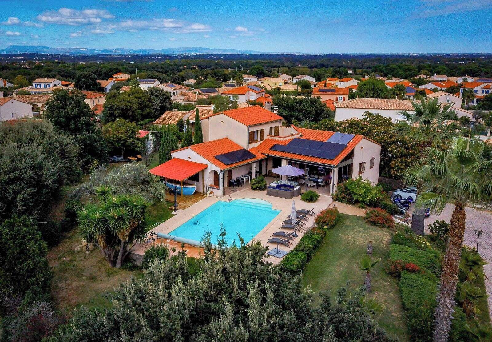 A residential property with a swimming pool, outdoor seating, and a view of a residential area.