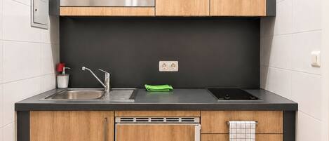 A modern kitchen with a microwave, sink, and stove.