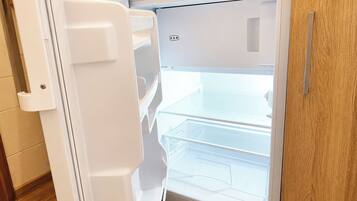 Ein weißer Kühlschrank mit separatem Gefrierfach, einem Griff und einer Bedienkonsole.