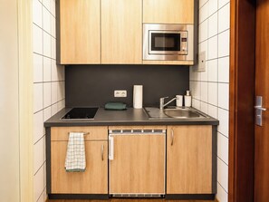 A compact kitchen with a built-in microwave, a sink, and a dishwasher. - Apartment Sleeps 2 with Balcony (Koblenz)