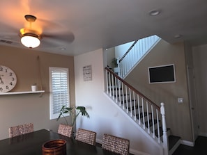 A dining area with a table, chairs, a clock, a ceiling fan, and a staircase. - Spacious 4-bedroom house in lovely Bakersfield with AC (Bakersfield)