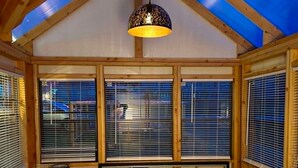 Un dormitorio con cama, mesita de noche, lámpara y tragaluz.
