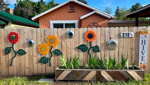 Una valla de madera con adornos florales y un letrero con número.