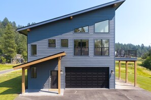 A two-story house with a garage, a covered porch, and a deck.