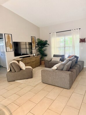 A living room with a flat-screen TV, two sofas, a coffee table, and a potted plant. - Family-Friendly Largo Retreat Near Beaches  Sleeps 7 (Largo)