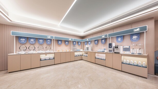 A modern cafe interior with a long counter, multiple service stations, and a clean, minimalist design.