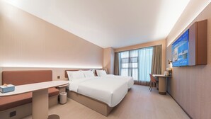 A modern hotel room with a bed, a desk, a chair, and a large window.