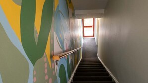 A staircase with a handrail, leading to a room with a window and a door at the top. - Seaview Family Stay Akaroa - Spacious, Sunny & 2 carparks - 2 min walk to waterfront (Akaroa)