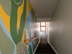 Eine Treppe mit Handlauf, die zu einem Raum mit Fenster und Tür führt.