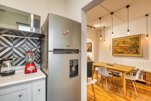 Eine moderne Küche mit einem Edelstahlkühlschrank, einem Mixer und einem Wasserkocher auf der Arbeitsfläche.