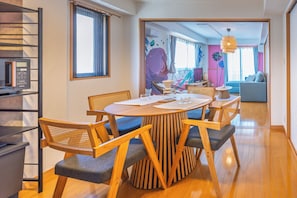 A dining area with a round table, wooden chairs, and a modern kitchen visible in the background. - THE AOCA TOKYO JIYUGAOKA (Setagaya-ku)