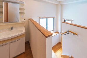 A bathroom with a sink, mirror, and wooden floor. - THE AOCA TOKYO JIYUGAOKA (Setagaya-ku)