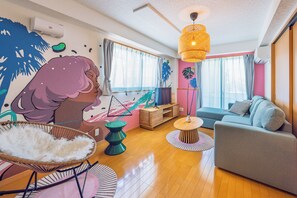 A modern living room with a sofa, a chair, a table, and a decorative wall mural. - THE AOCA TOKYO JIYUGAOKA (Setagaya-ku)