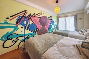 A hotel room with two beds, a colorful mural, a hanging light fixture, and a window with curtains. - THE AOCA TOKYO JIYUGAOKA (Setagaya-ku)