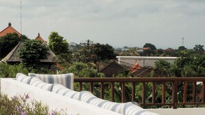 A white balcony with a railing, overlooking a residential area with houses and greenery. - Villa Lurline (Kuta Selatan)