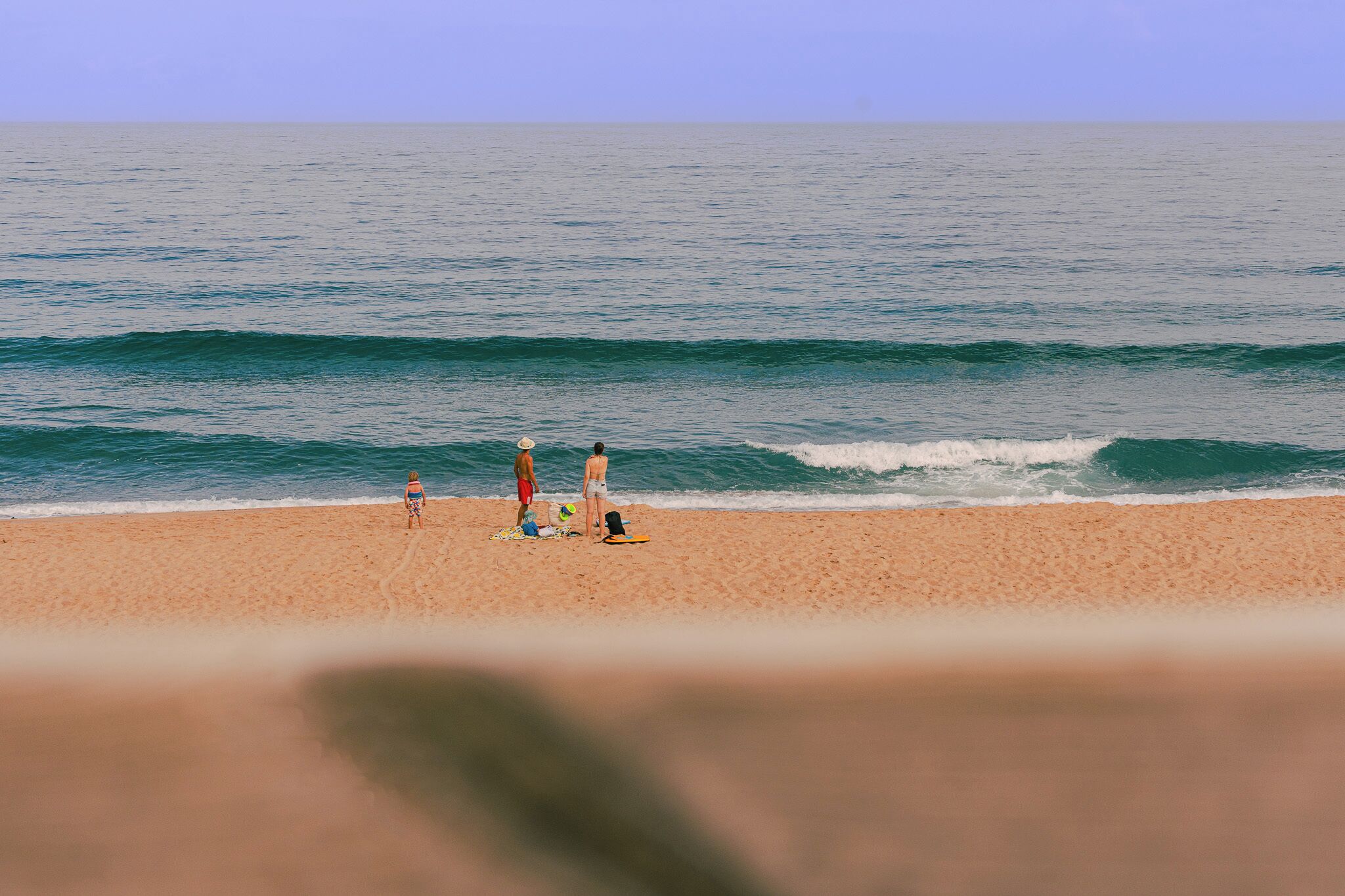 A beach with a clear view of the ocean and a sandy shore.