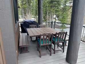 A wooden deck with a table and chairs, a barbecue grill, and a railing. - New Listing! Slopeside at Cowboy Heaven (Big Sky)