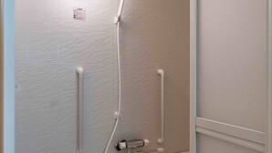 Un bagno moderno con doccia, maniglie di sostegno, portasci e vasca da bagno.