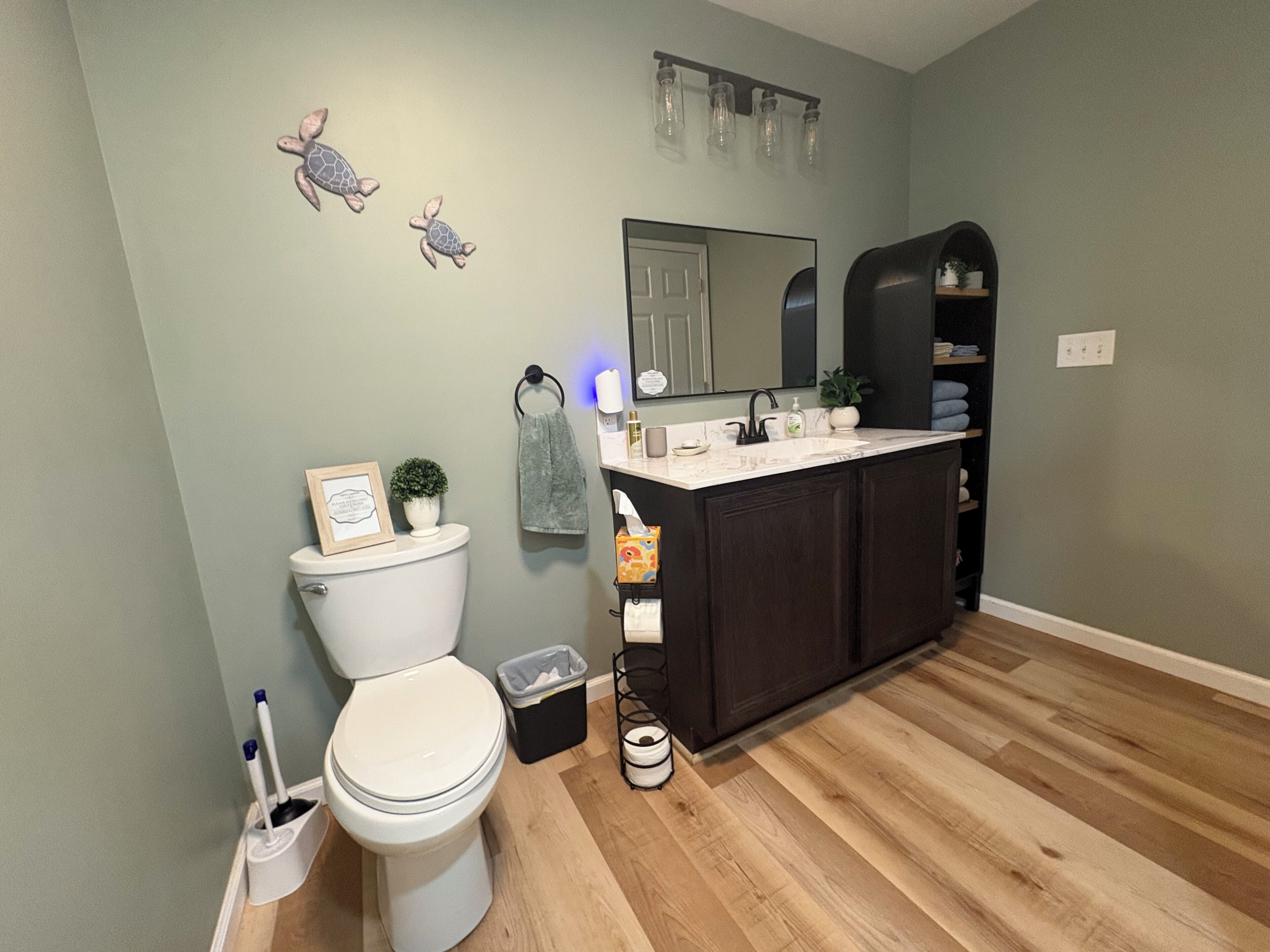 Ein Badezimmer mit Toilette, Waschbecken und dunklen Holzsärchen.