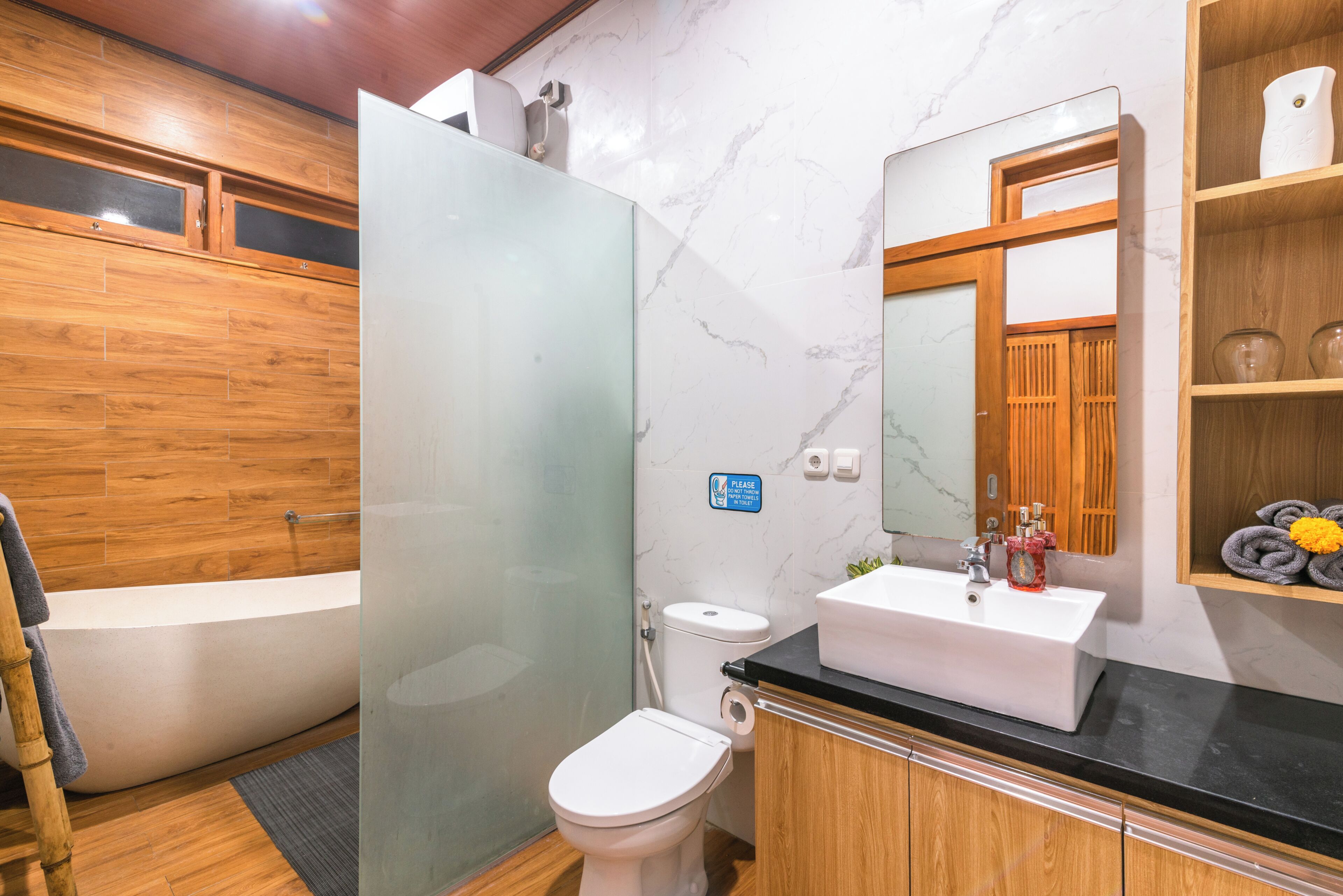 Un bagno moderno con cabina doccia in vetro, un water bianco, una vasca da bagno e un mobile lavabo con specchio.