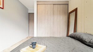 A bedroom with a bed, a bedside table with a mug, and a wooden headboard. - Napoles Elegance · A pasos de WTC (Ciudad de México)