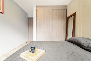 A bedroom with a bed, a bedside table with a mug, and a wooden headboard. - Napoles Elegance · A pasos de WTC (Ciudad de México)