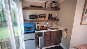 A compact kitchen with a microwave, toaster, coffee maker, and a small trash bin. - Studio Guesthouse with AC in charming Decatur (Decatur)