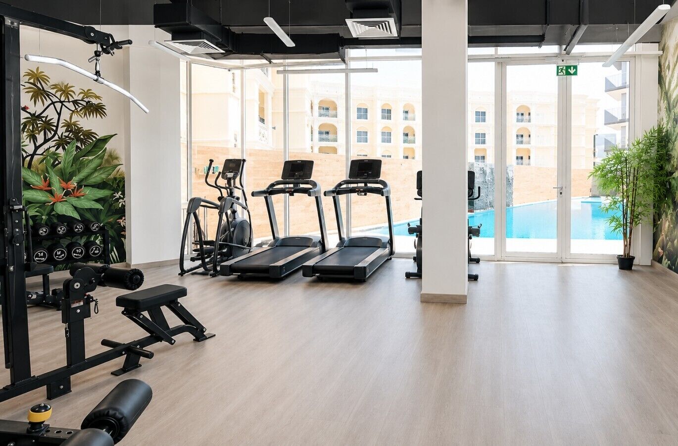 A gym with treadmills, a weight bench, and a rowing machine.