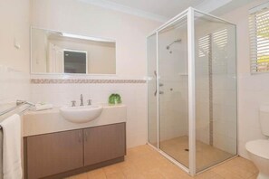 A bathroom with a glass-enclosed shower, a sink, and a toilet. - Station Road Retreat (Margaret River)