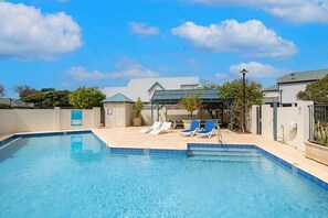 A swimming pool with lounge chairs and a covered seating area. - Gas Bay Beach House Margaret River (Gnarabup)