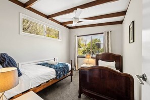 A bedroom with a bed, bedside table, lamp, and a ceiling fan. - Forest View Retreat Margaret River (Margaret River)