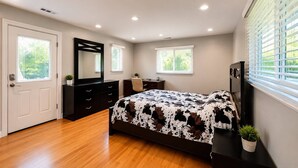 Un dormitorio con cama, cómoda, espejo y ventana con persianas.