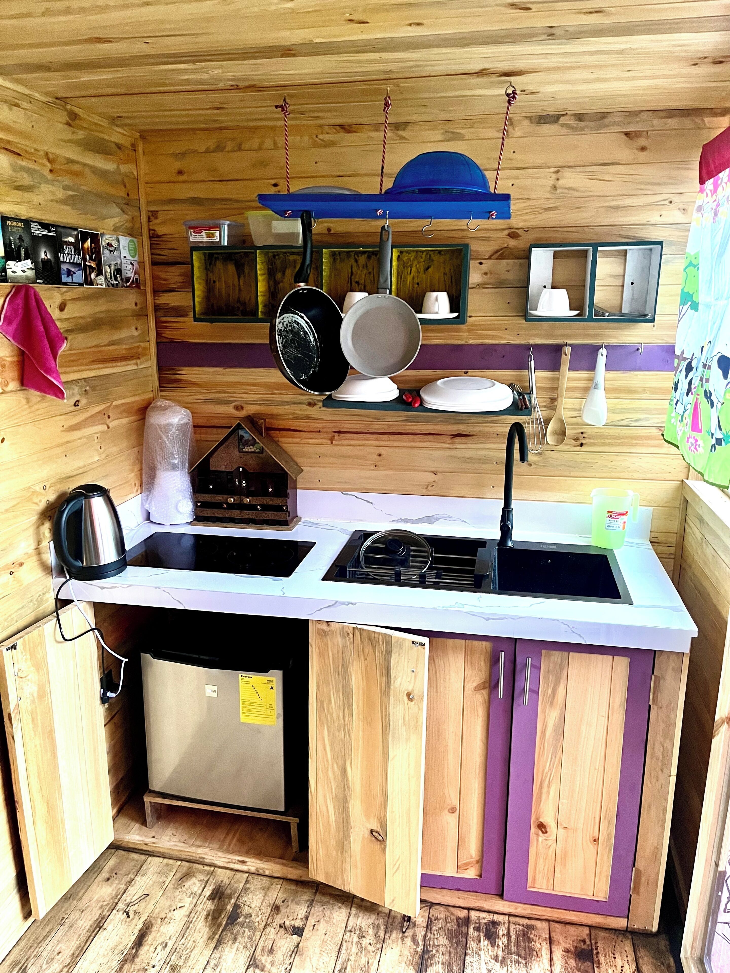 A compact kitchen with wooden cabinets, a sink, and a stove.