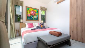 Un dormitorio moderno con una cama, un banco, un cuadro y un equipo de aire acondicionado.