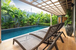 A poolside area with lounge chairs and a pergola. - Resort Pool Villa Dalaa 9 (Kathu)