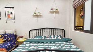Ein Schlafzimmer mit einem Bett, einem Nachttisch, einer Wandablage und einem Fenster mit Vorhängen.