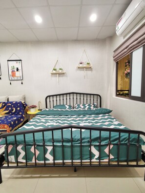 Ein Schlafzimmer mit einem Bett, einem Nachttisch, einer Wandablage und einem Fenster mit Vorhängen.
