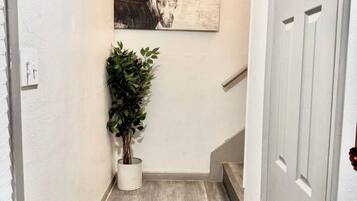 A staircase with a wooden finish, a potted plant, and a wall-mounted artwork.